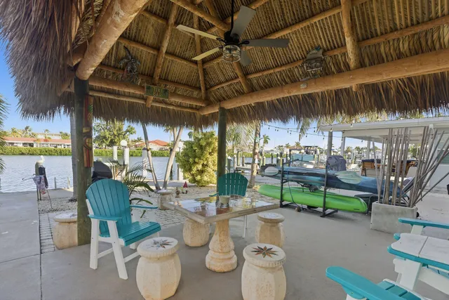 a view of a patio with table and chairs potted plants and palm trees