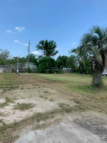 a view of a field with trees in background