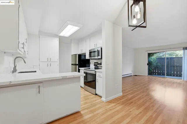 a kitchen with stainless steel appliances a dining table and chairs