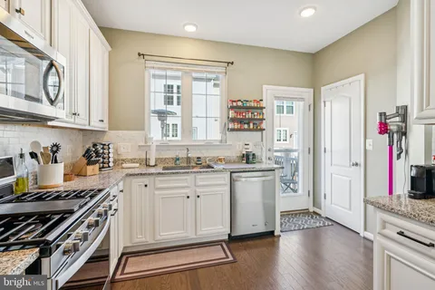 a kitchen with stainless steel appliances granite countertop a stove and cabinets