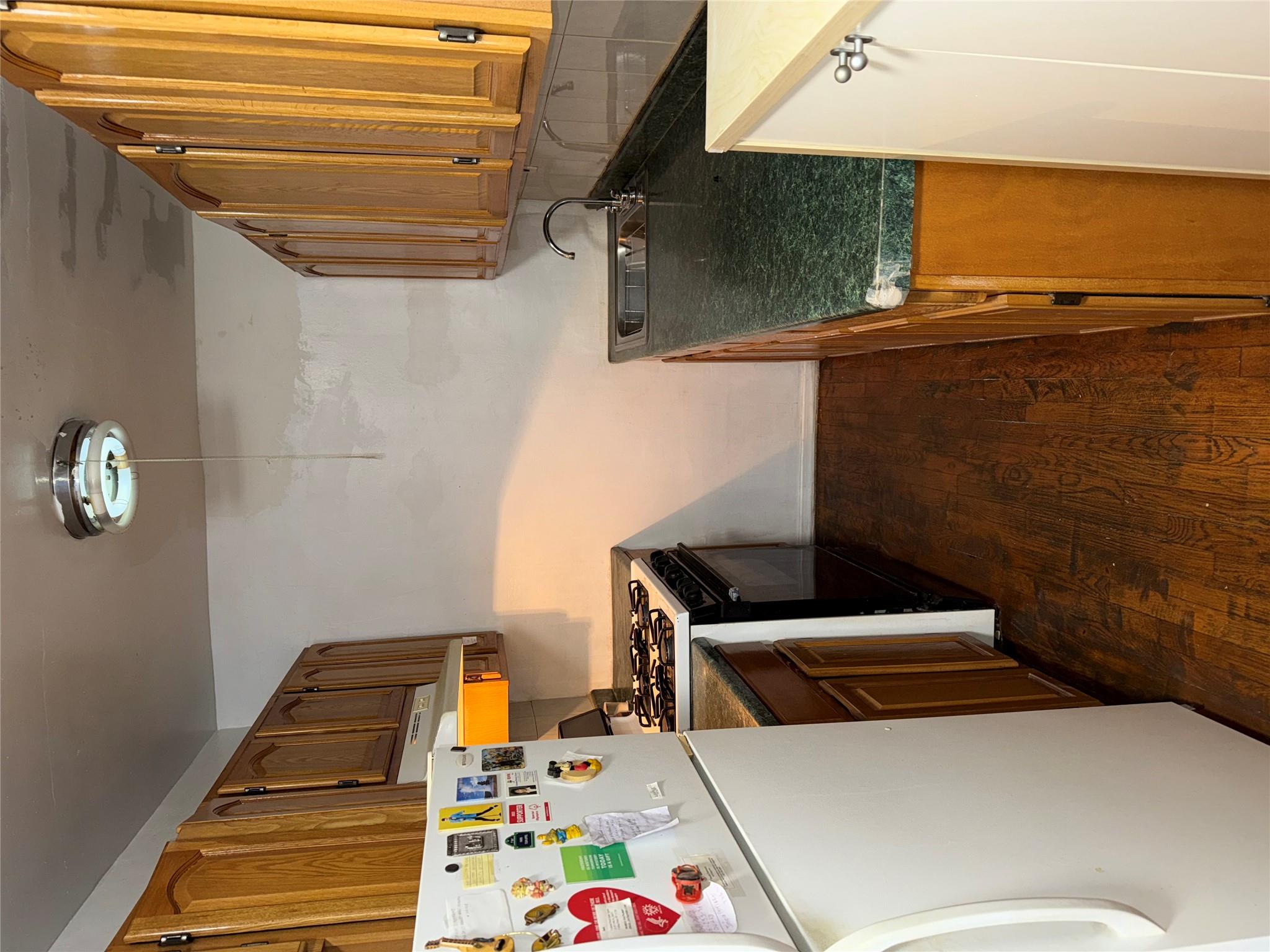 42-04 Layton Street, Unit 311 Queens, NY 11373 - Photo 2 of 4 Kitchen with refrigerator, sink, dark hardwood / wood-style flooring, stove, and exhaust hood
