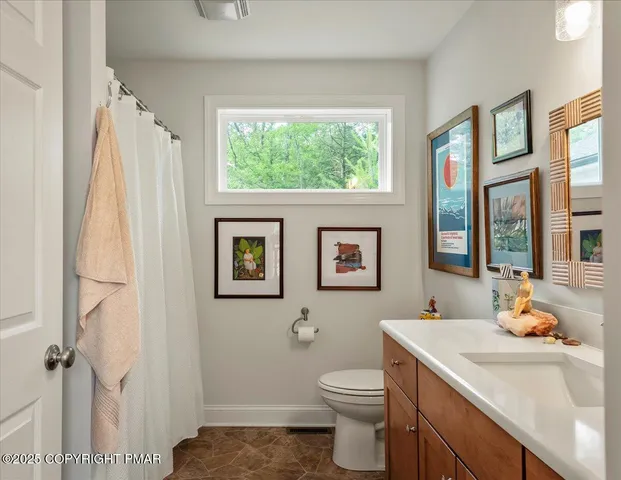 a bathroom with a sink toilet and window