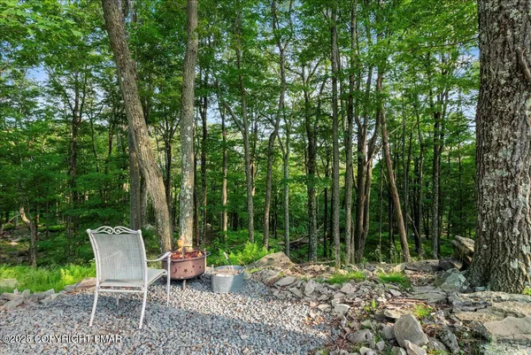 a view of a chairs and table in the backyard