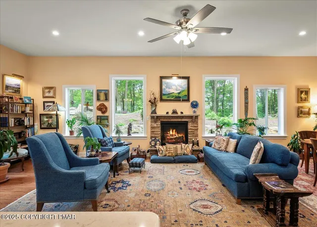 a living room with furniture a fireplace and a large window