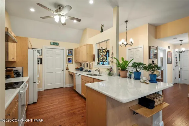 a kitchen with stainless steel appliances kitchen island granite countertop a stove a sink and a refrigerator