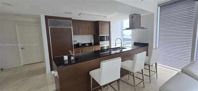 a kitchen with a table chairs refrigerator and microwave