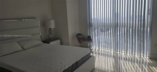 a bedroom with a bed and a large window