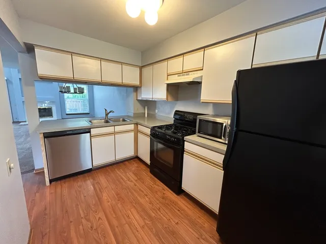 a kitchen with a refrigerator stove top oven and sink
