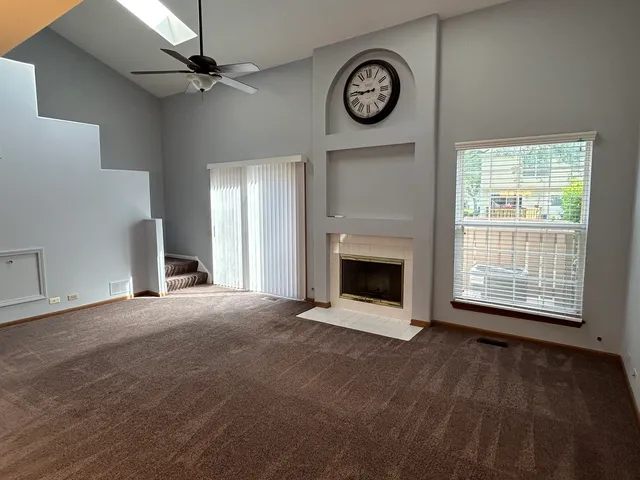 an empty room with a fireplace and windows