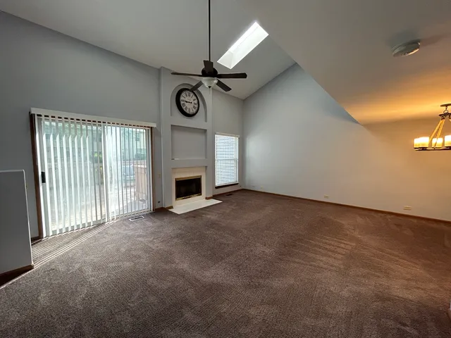 a view of an empty room with a fireplace and a window