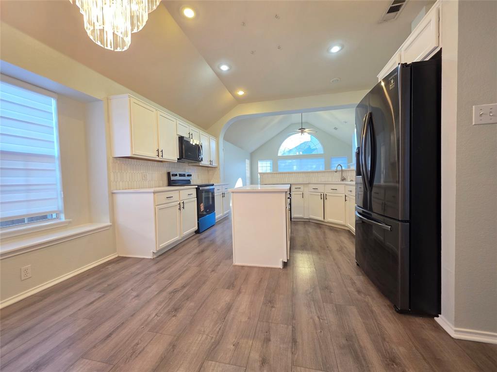 3124 Nighthawk Lane Little Elm, TX 75068 - Photo 2 of 13 a kitchen with a refrigerator a stove top oven a sink dishwasher and a refrigerator with wooden floor
