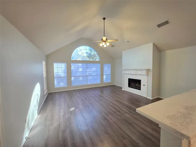a view of a livingroom with a chandelier wooden floor and a fireplace