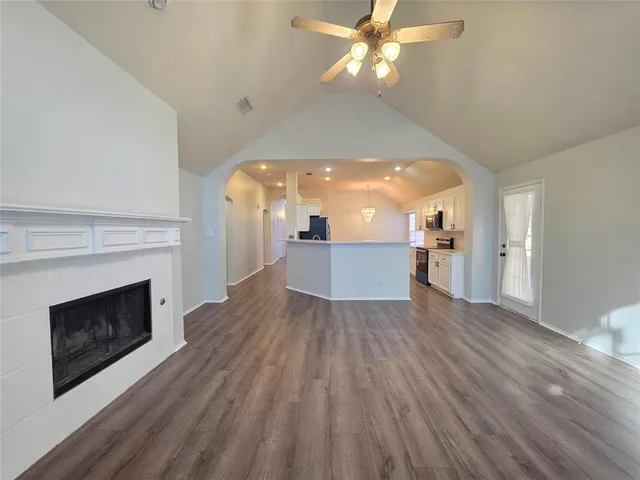a view of a livingroom with wooden floor and a fireplace