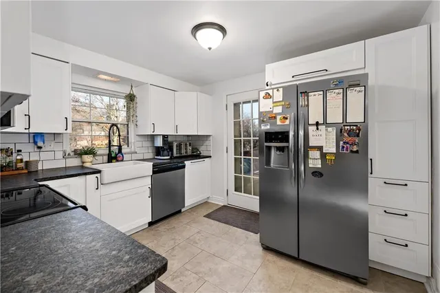 a kitchen with stainless steel appliances granite countertop a refrigerator a stove and a sink