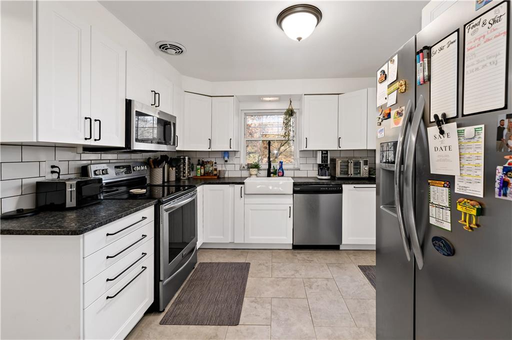203 Washington Road Pittsburgh, PA 15221 - Photo 12 of 36 a kitchen with a sink a refrigerator and cabinets