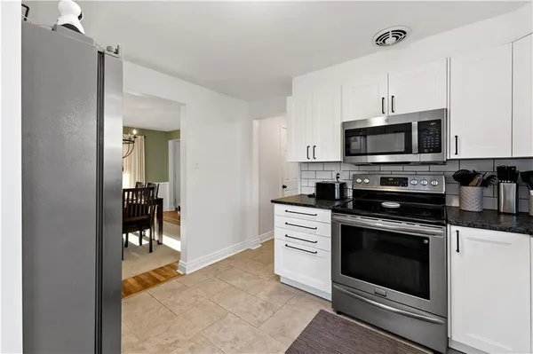 a kitchen with stainless steel appliances granite countertop a stove microwave and cabinets