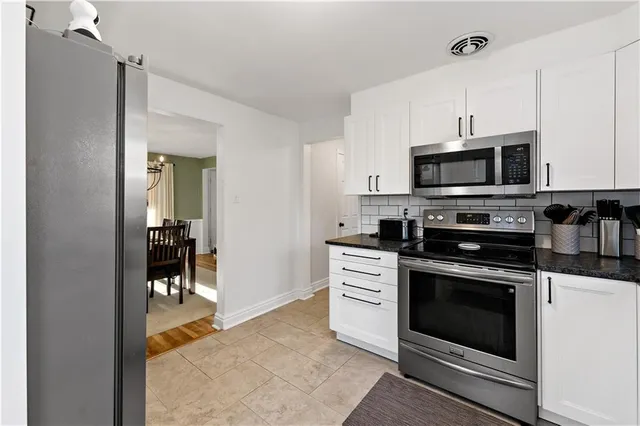 a kitchen with stainless steel appliances granite countertop a stove microwave and cabinets