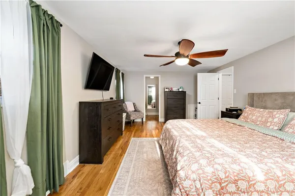 a spacious bedroom with a bed and a flat screen tv