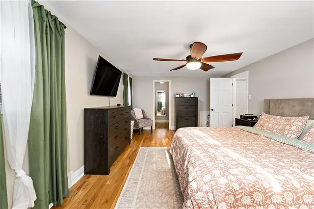 a spacious bedroom with a bed and a flat screen tv