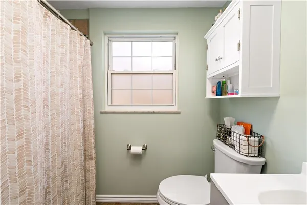 a white toilet sitting next to a bathroom sink and vanity