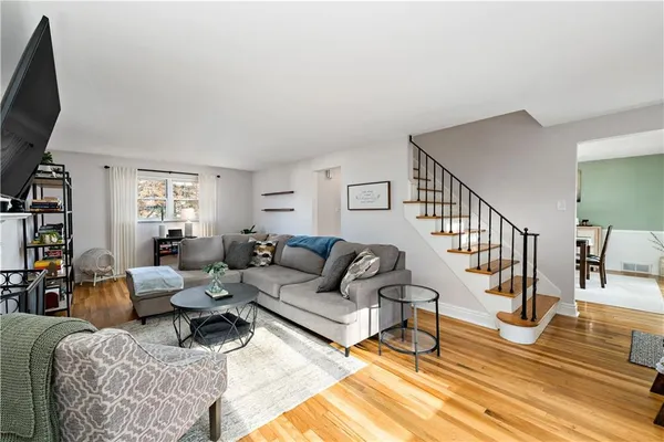 a living room with furniture a rug and a flat screen tv