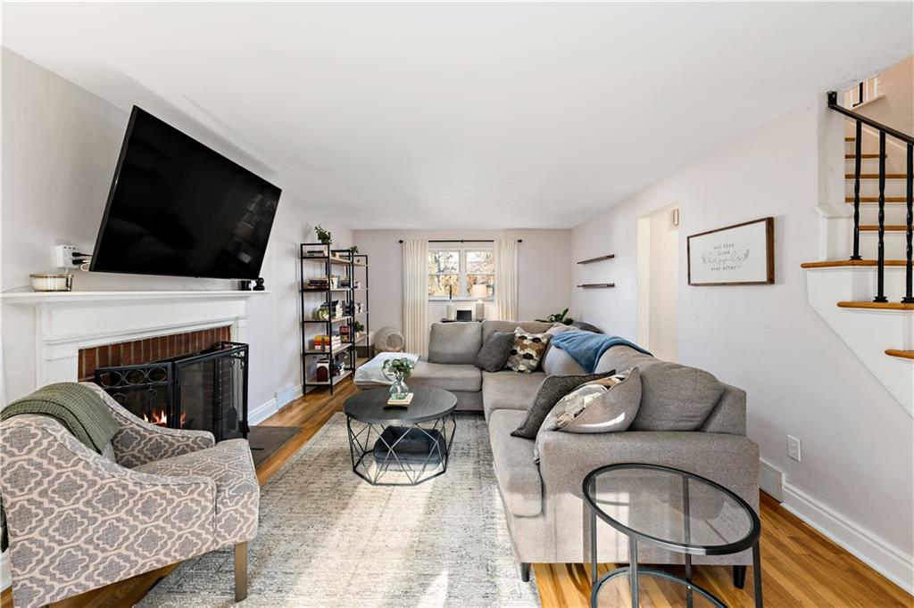 203 Washington Road Pittsburgh, PA 15221 - Photo 8 of 36 a living room with furniture a fireplace and a flat screen tv