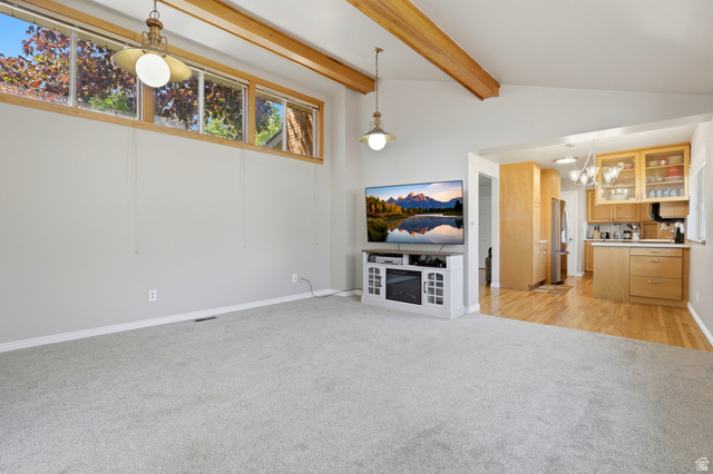 4245 3320 East Holladay, UT 84124 - Photo 18 of 51 Vaulted ceilings with exposed wood beams highlight this open-concept living space
