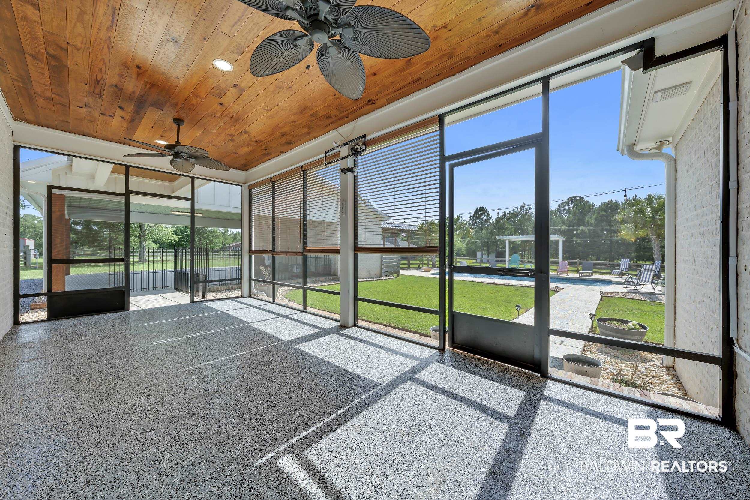 6576 Ranch Loop Road East Grand Bay, AL 36541 - Photo 32 of 39 Expansive screened patio featuring wood-finish ceiling, dual ceiling fans, and speckled flooring