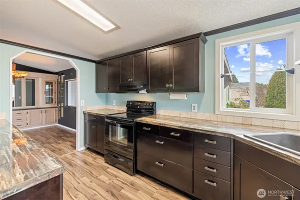 a kitchen with stainless steel appliances granite countertop a sink stove and cabinets