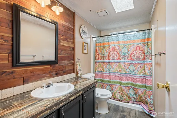 a bathroom with a sink a toilet and shower curtain