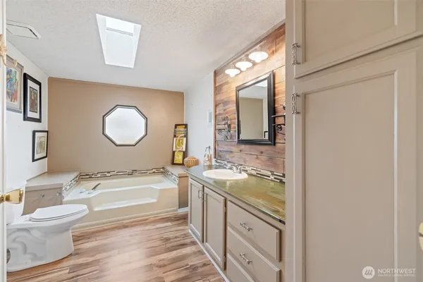 a bathroom with a granite countertop sink mirror vanity and toilet