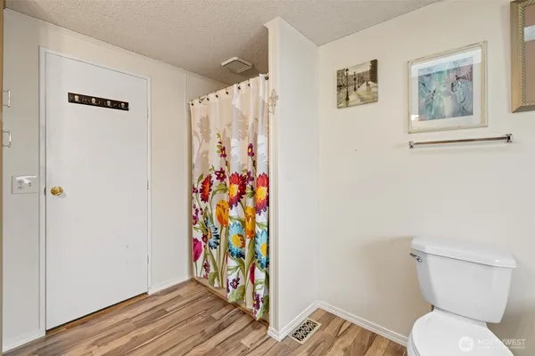 a bathroom with a toilet and a shower curtain