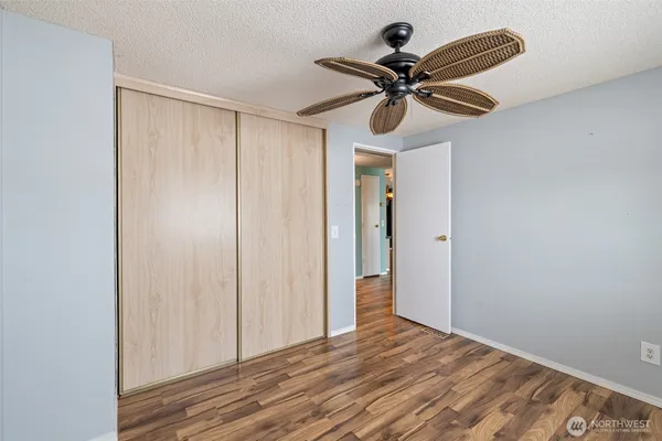 a view of a livingroom with a ceiling fan and wooden floor