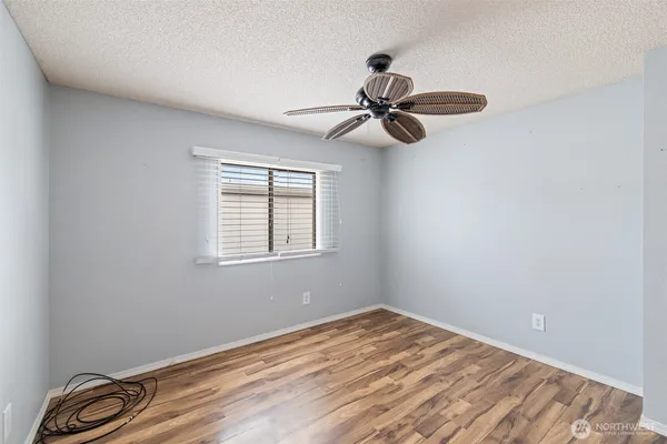 a view of a room with a ceiling fan and wooden floor
