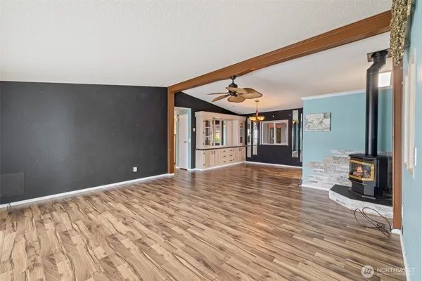 a view of an empty room with wooden floor and a large window