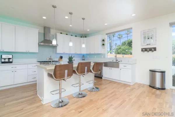 a kitchen with a dining table chairs sink and cabinets