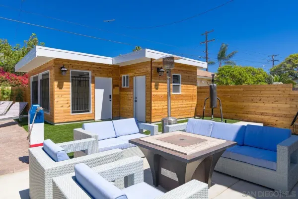a view of a patio with couches table and chairs with potted plants