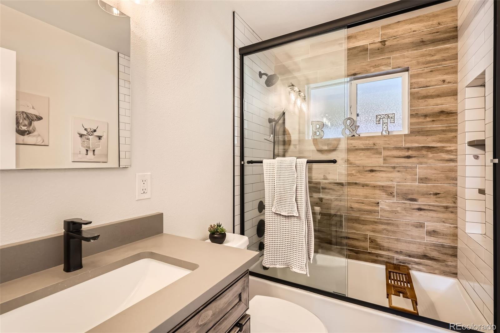 7120 Galapago Street Denver, CO 80221 - Photo 13 of 30 a bathroom with a shower sink and mirror