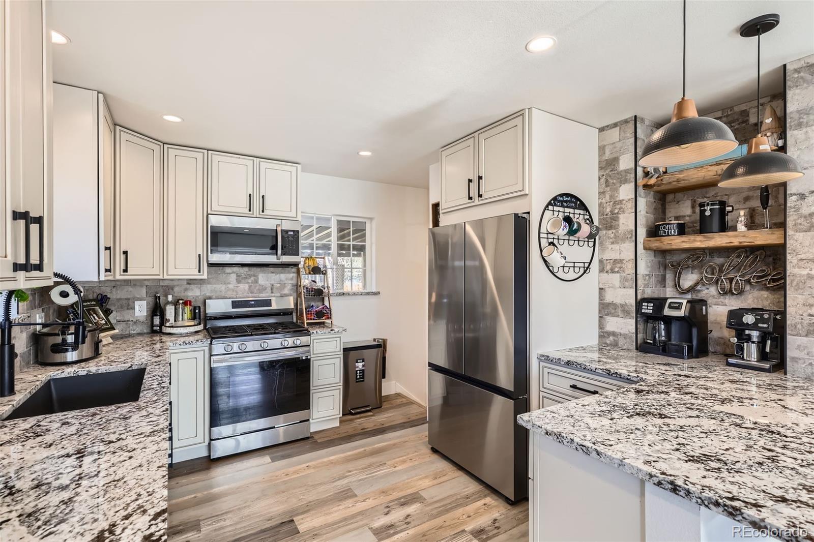 7120 Galapago Street Denver, CO 80221 - Photo 7 of 30 a kitchen with stainless steel appliances granite countertop a refrigerator a stove and a sink with wooden floor