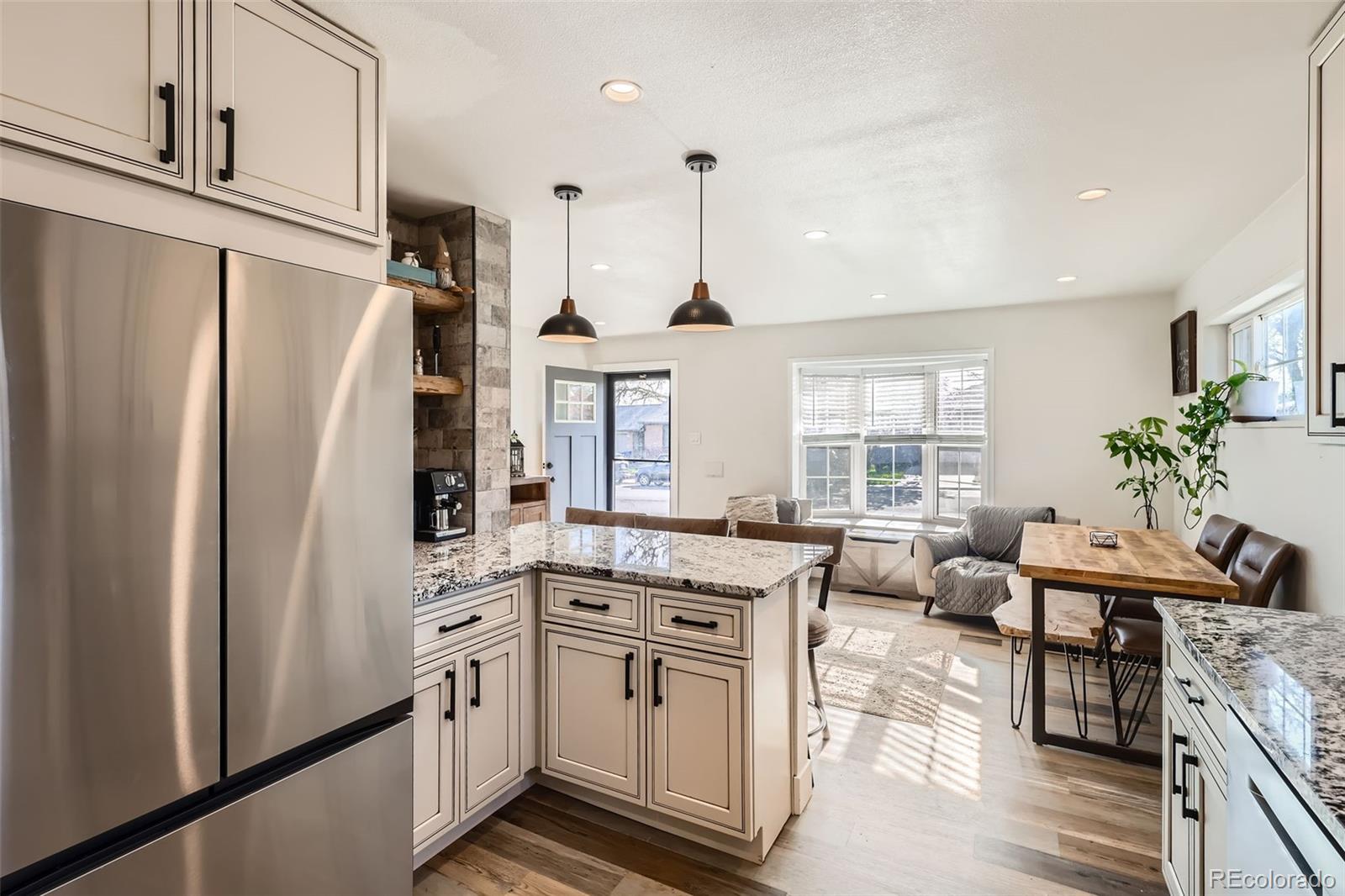 7120 Galapago Street Denver, CO 80221 - Photo 9 of 30 a kitchen with stainless steel appliances a refrigerator a stove a sink dishwasher a oven with white cabinets and wooden floor