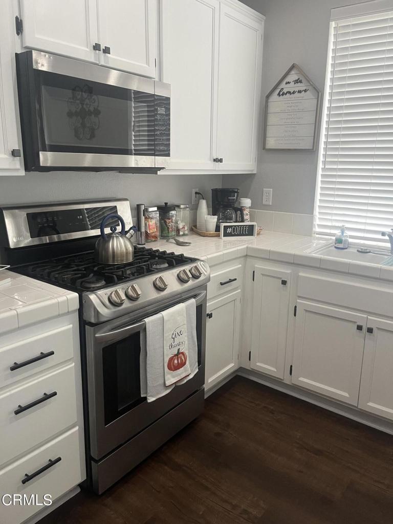 1027 Corte Primavera Oxnard, CA 93030 - Photo 11 of 23 a white stove top oven sitting inside of a kitchen