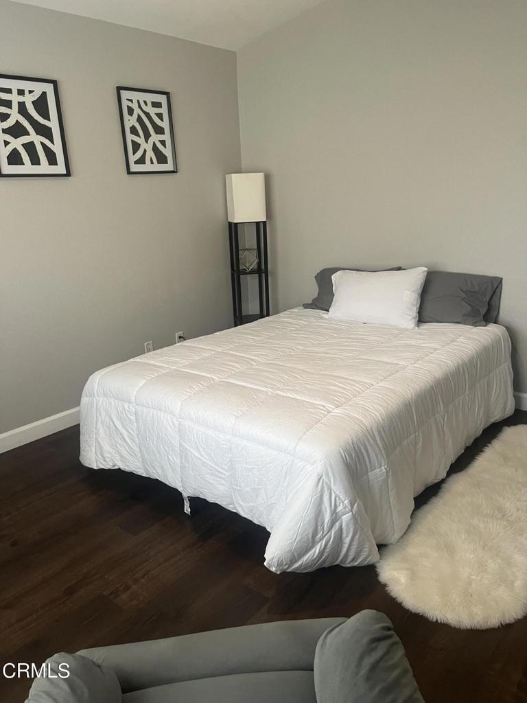 1027 Corte Primavera Oxnard, CA 93030 - Photo 15 of 23 a bedroom with a bed and wooden floor