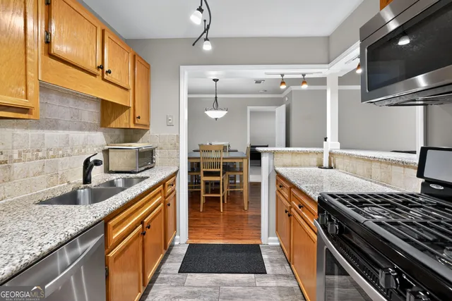 a kitchen with stainless steel appliances granite countertop a sink and a stove