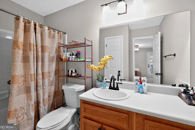 a bathroom with a toilet and a shower curtain