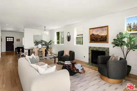 a living room with furniture a fireplace and potted plants
