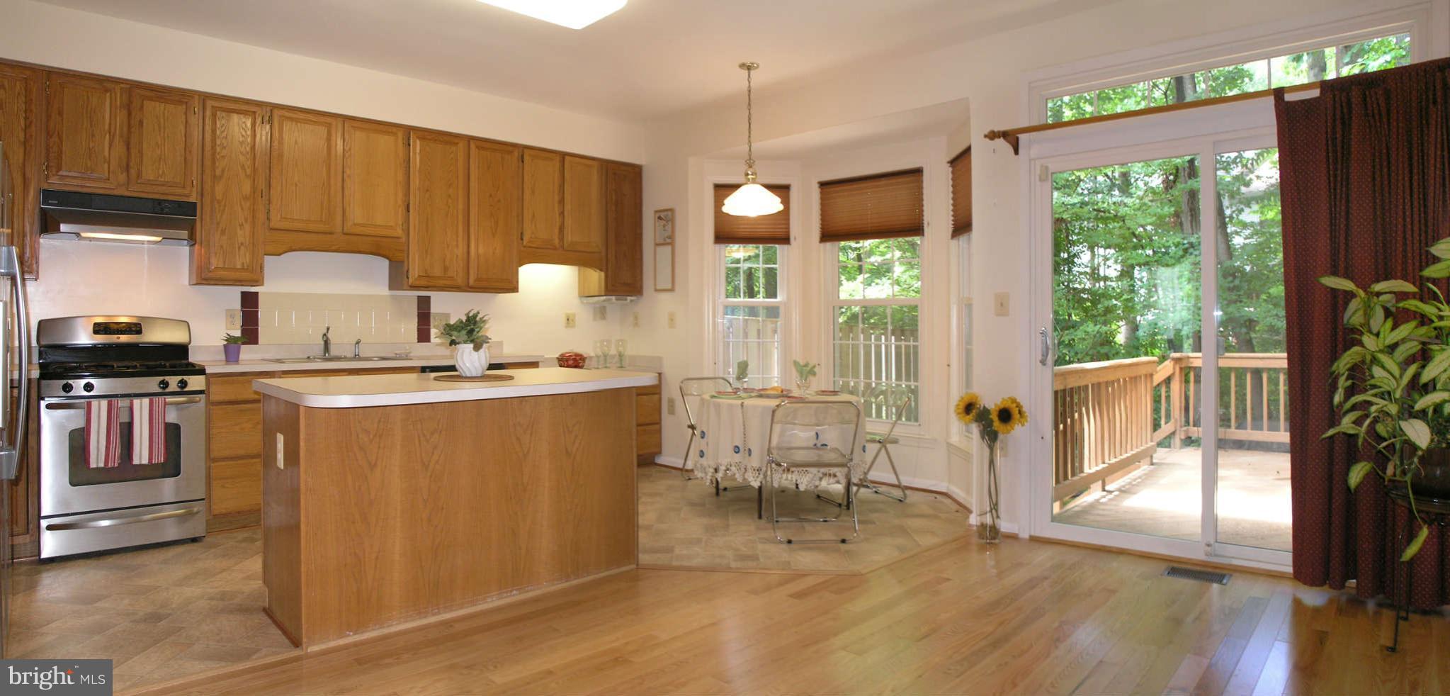 11294 Fairwind Way Reston, VA 20190 - Photo 12 of 30 a kitchen with stainless steel appliances granite countertop a refrigerator a sink a stove and wooden floors