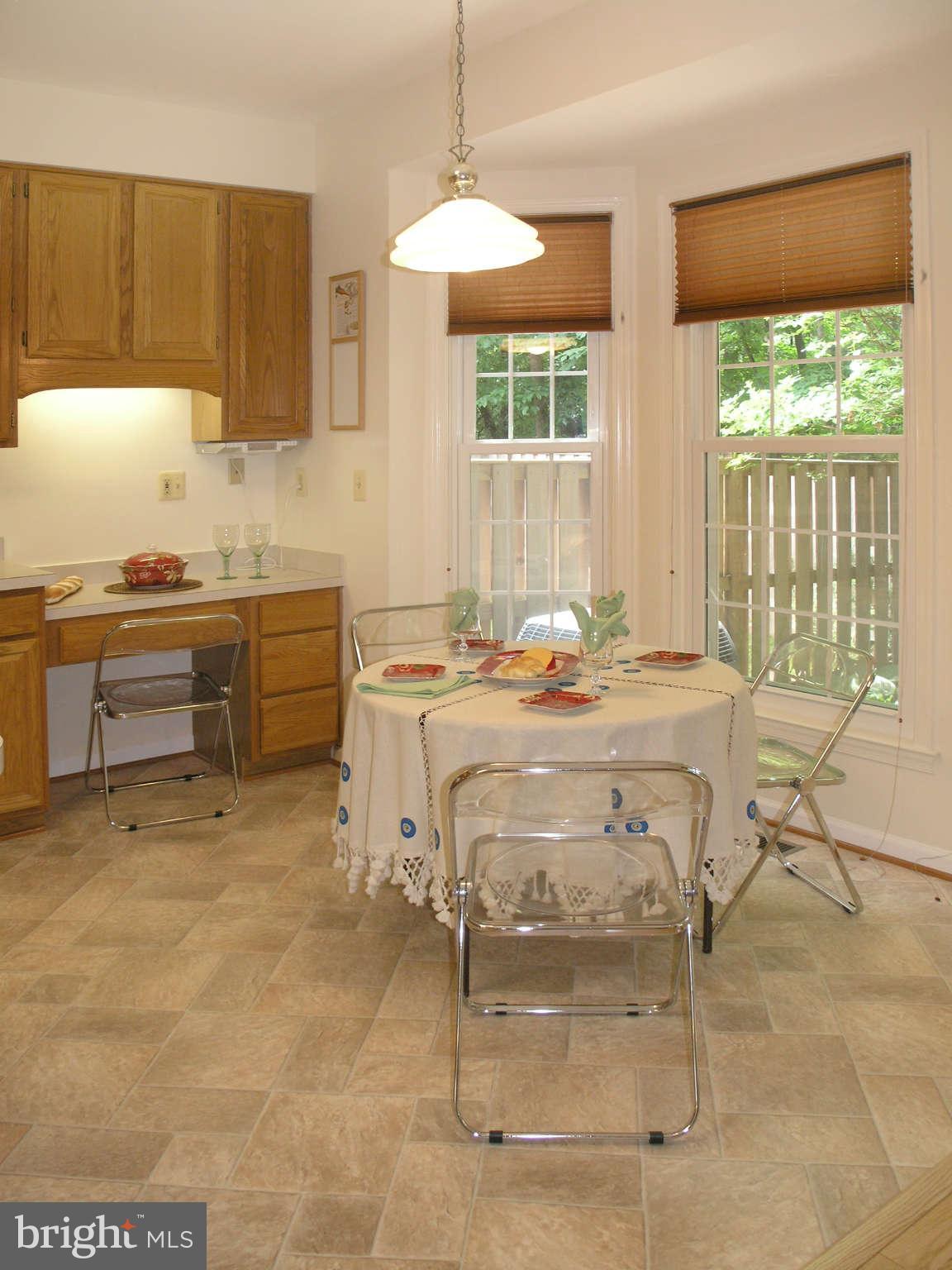 11294 Fairwind Way Reston, VA 20190 - Photo 15 of 30 a kitchen with stainless steel appliances kitchen island granite countertop a table and chairs in it