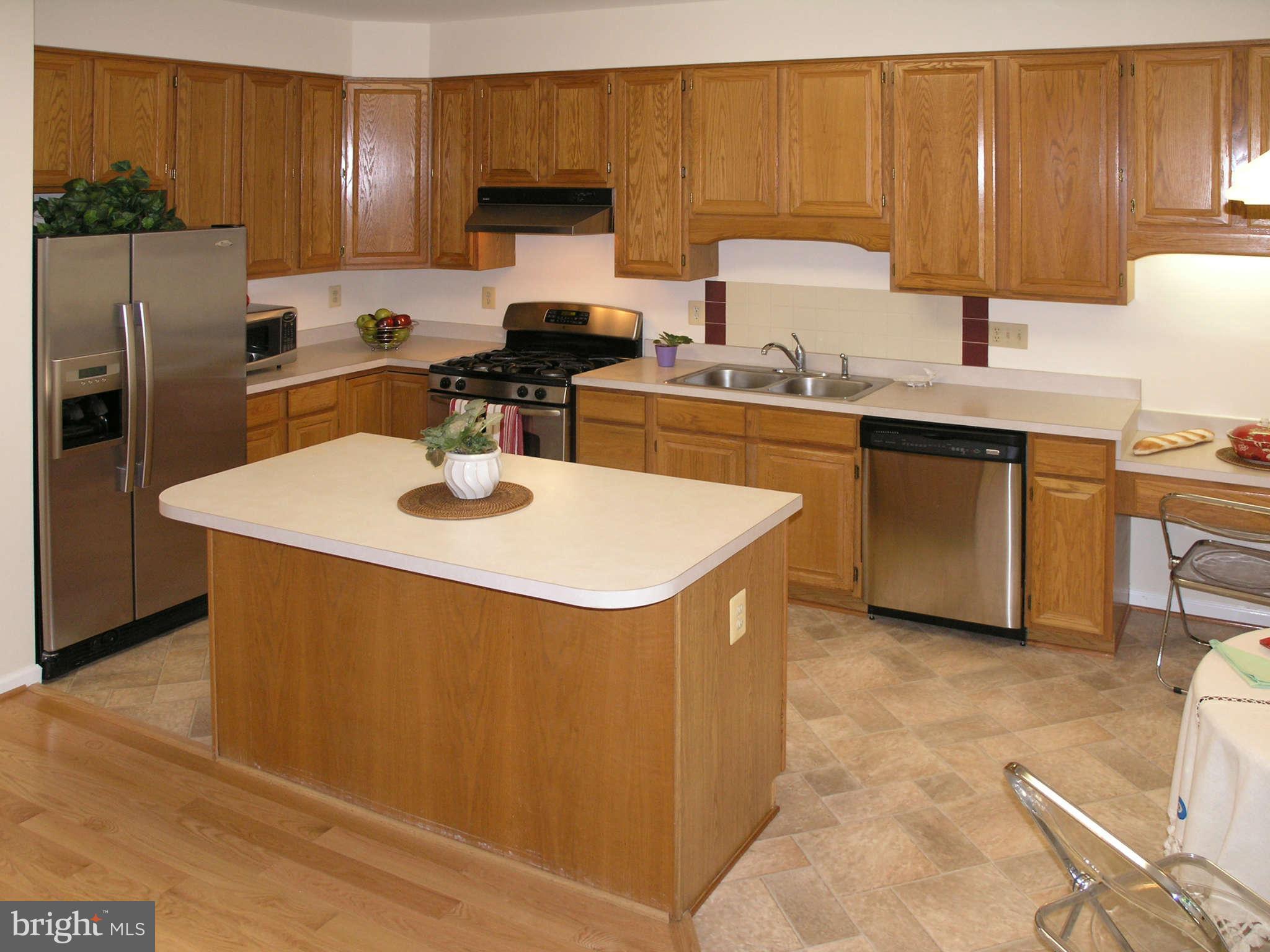 11294 Fairwind Way Reston, VA 20190 - Photo 16 of 30 a kitchen with a sink a stove a refrigerator and cabinets