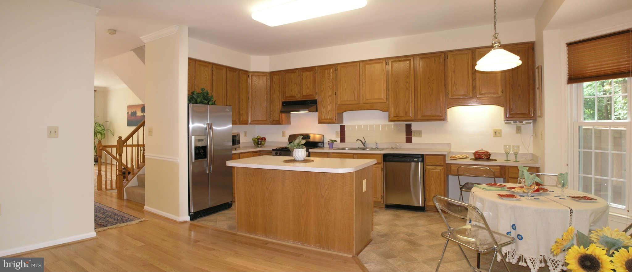 11294 Fairwind Way Reston, VA 20190 - Photo 17 of 30 a kitchen with kitchen island a sink appliances and cabinets