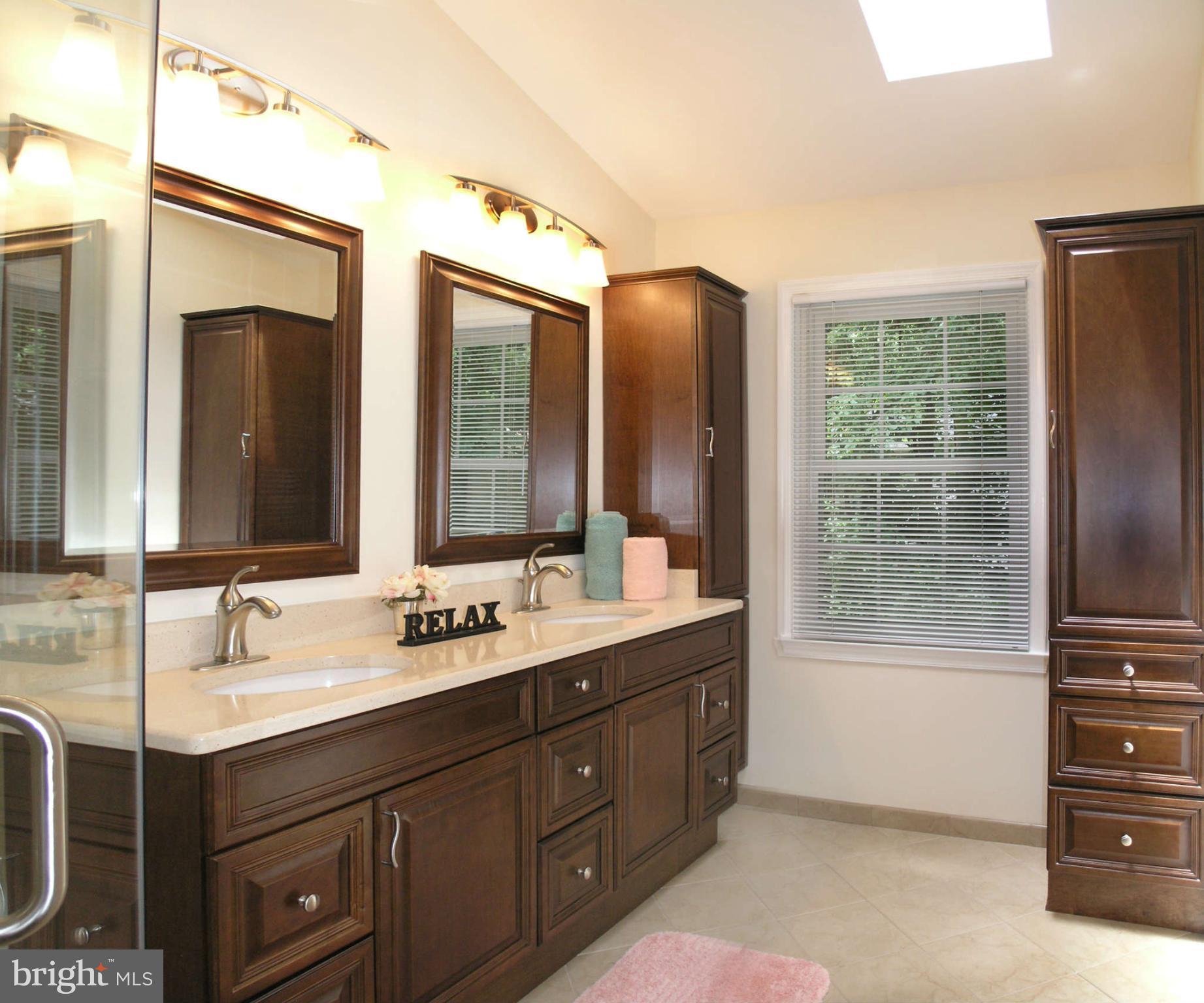 11294 Fairwind Way Reston, VA 20190 - Photo 22 of 30 a bathroom with a double vanity sink a mirror and a bathtub